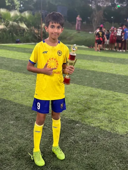 Pointing to the badge. This player shows his pride for the academy while holding his individual award.