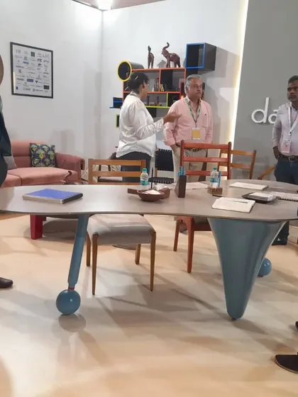 A group of architects and designers discussing the details of my custom-designed table at the iDAC booth.