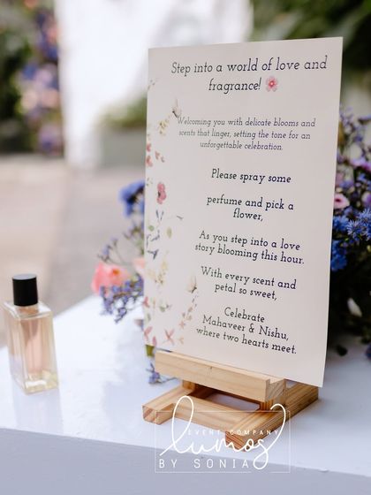 A "Step into a world of love and fragrance" sign, inviting guests to spray perfume and pick a flower upon arrival.