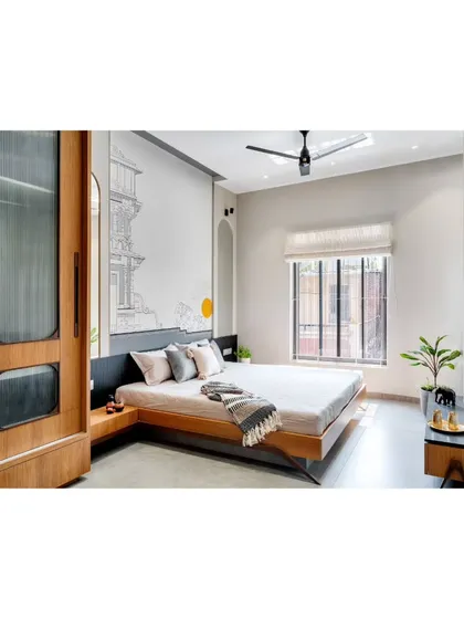 A minimalist bedroom design with a low platform bed and a custom wooden wardrobe with fluted glass panels.