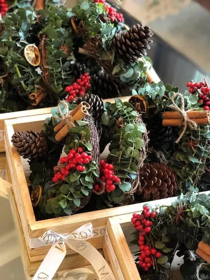 Spreading holiday cheer with mini wreaths. These were created as a heartwarming store giveaway, featuring eucalyptus, red berries, pinecones, and cinnamon, all packed in our custom wooden crates.