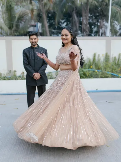 A fun, twirling shot that shows off the movement of the lehenga. Her radiant smile and glowing makeup complete this perfect engagement moment.
