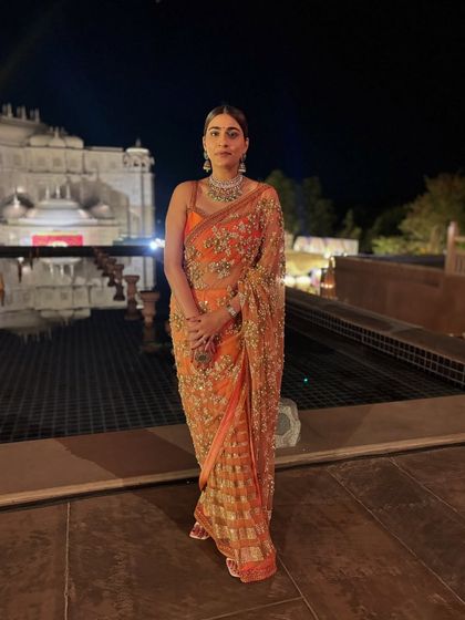 There's nothing like a palace wedding. Here I am in a gorgeous orange Sabyasachi saree, a perfect choice for a grand, regal celebration.