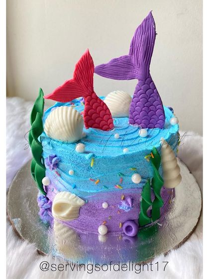 Another take on my popular mermaid theme cake, with vibrant red and purple tails diving into a buttercream ocean.