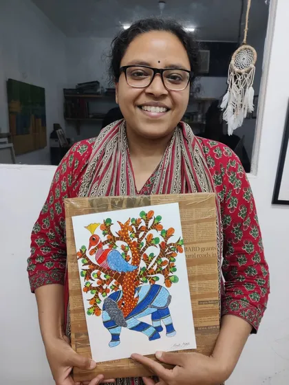 A participant beams with pride, holding her completed Gond art piece. This workshop dives into the unique patterns and storytelling of this beautiful Indian folk art.