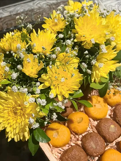 Introducing our festive sweet tray! Perfect for a Haldi ceremony or other wedding events, this tray combines bright yellow chrysanthemums with traditional Indian sweets like pedas and laddoos.