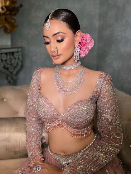 The bride seated, her pastel lehenga and soft glam makeup creating a picture of serene beauty.