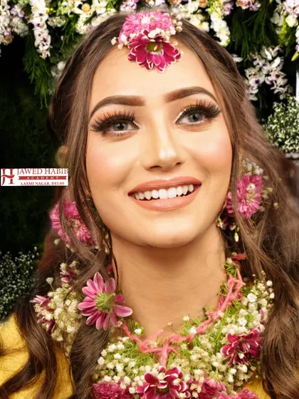 A bright and joyful Haldi look, featuring natural-looking makeup and fresh floral jewelry. This is a perfect example of the pre-wedding event makeup we teach.