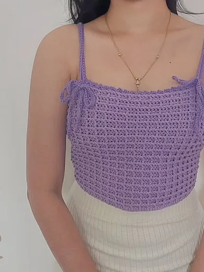 This is the Aurelia Top, a modern piece featuring a waffle stitch texture and a unique V-shaped hem.