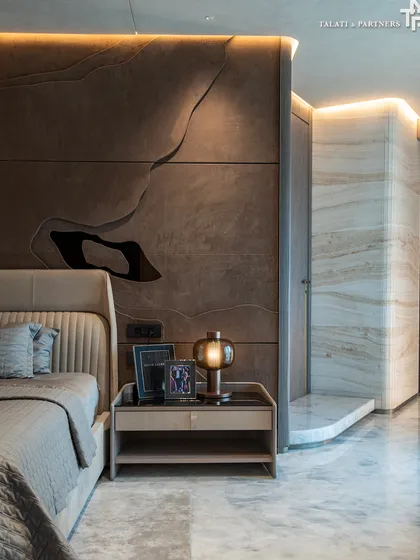 In this plush bedroom at Lodha World View, seamless marble cladding elegantly conceals structural columns, creating a fluid and uninterrupted aesthetic. This meticulous attention to detail transforms the bedroom into a tranquil retreat, where our mastery of precision craftsmanship radiates sophistication and calm.
