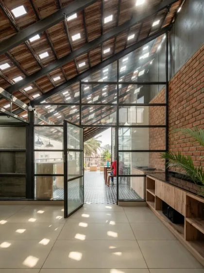 For our Earthen Spirit project, we designed this open terrace to be a hub of activity. The sloping roof features traditional Mangalore tiles with glass inserts, a design that scatters natural light across the floor in shifting patterns. This approach creates a bright, dynamic atmosphere that changes throughout the day, connecting the indoor space with the rhythm of the sun.