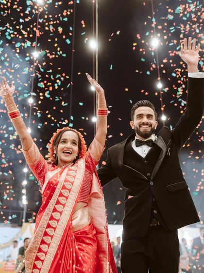 The grand finale of their entrance. Ryan and Ela, hands raised in celebration under a sky of confetti, perfectly capture the triumphant and joyous spirit of their wedding day.
