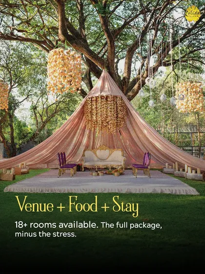 We create magical settings for your most important vows. This outdoor mandap, set under a grand tree, shows how we transform our green lawns into a breathtaking venue for your dream wedding.