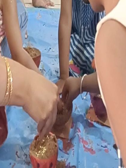 Children add the finishing touches to their painted coconut shells, a unique and eco-friendly craft idea.