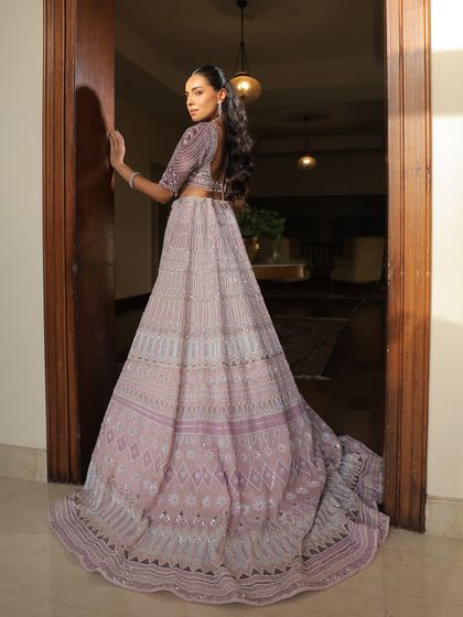 The back view of this stunning lavender lehenga, showcasing the detailed embroidery and the elegant cut of the blouse.
