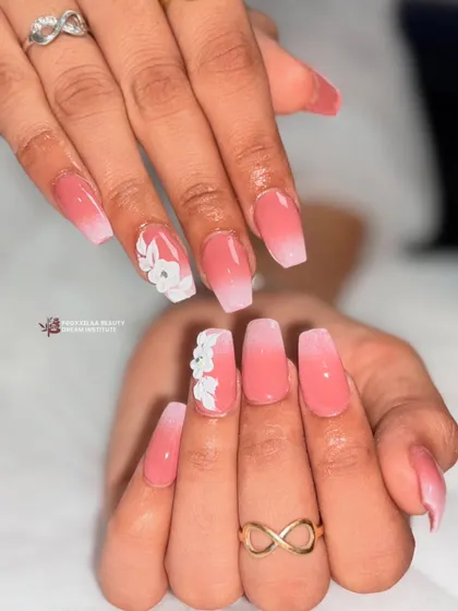 This view showcases the smooth gradient of the ombre and the clean application of the 3D floral art, creating a soft yet impactful manicure.