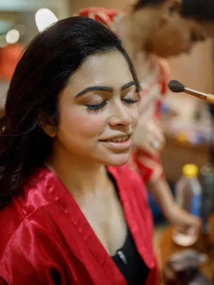 A behind-the-scenes shot of the makeup application. Even in the process, her skin looks smooth and her features are softly enhanced.