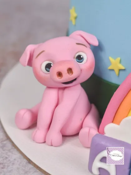 A detailed shot of the sweet little pig figurine from the Cocomelon-themed birthday cake.