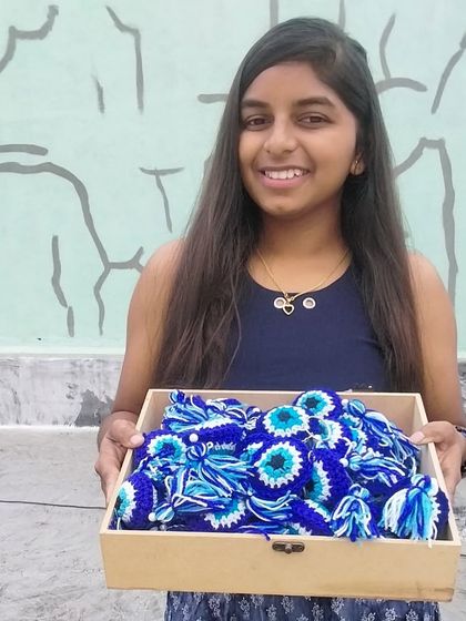 A proud moment, holding a tray full of my handmade evil eye keychains. This is the passion I bring to every single order.