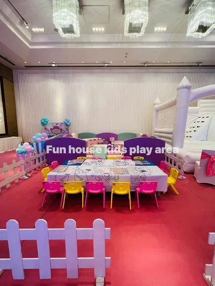 A complete indoor party package featuring our pastel soft play area, a white bouncy castle, and our colorful rainbow chairs, all enclosed by a white picket fence for a safe and organized fun zone.