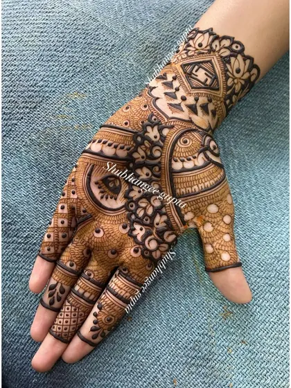 This design features a swastika symbol and a peacock, both important motifs in Indian culture. The surrounding patterns are intricate and traditional.