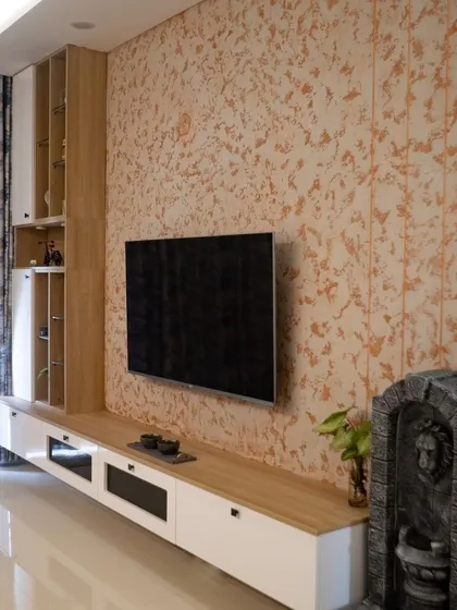 This TV unit is designed to be a feature, not just a utility. The large scale, textured wallpaper background, and clean lines of the console help it blend beautifully with the living room decor while providing ample storage.