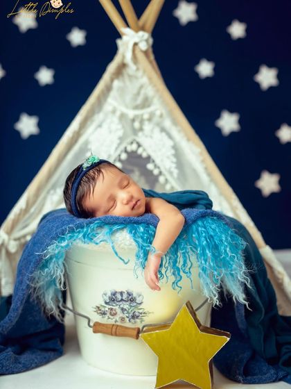 To the moon and back. This celestial theme features a starry night backdrop and a cozy teepee, creating a dreamy setting for your little one's newborn photos.