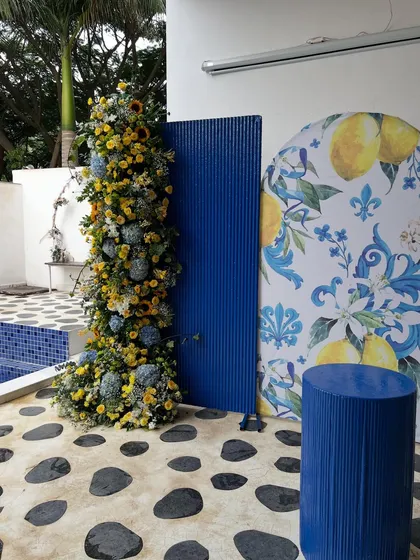 We brought a slice of the Amalfi Coast to Bangalore for this 40th birthday. The decor features a vibrant blue and yellow color scheme, custom lemon-print backdrops, and lush floral arrangements with sunflowers and hydrangeas for a fresh, summery feel.