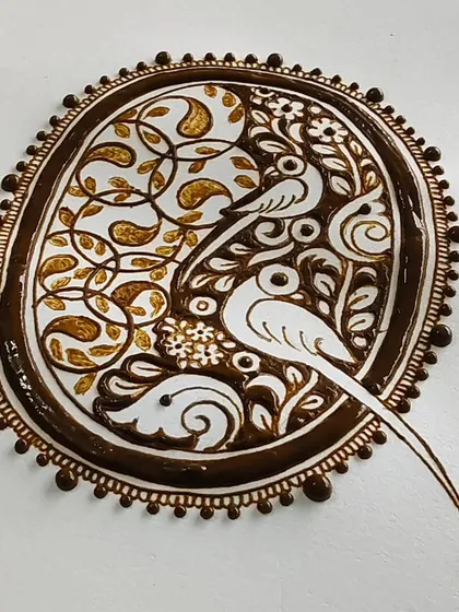 The parrot cutwork design with the henna paste freshly applied. The contrast between the filled and empty spaces is key to this style.