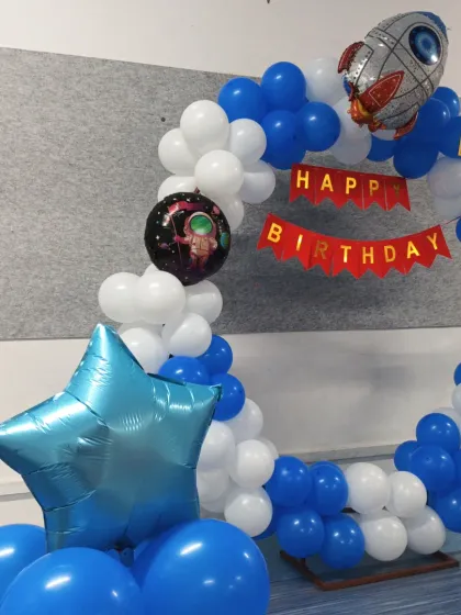 A side view of the astronaut theme decor, highlighting the star-shaped foil balloon pillar.