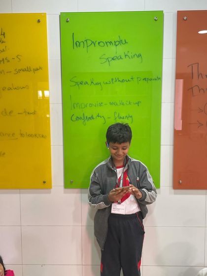 Using a mobile phone as a prompt, this student prepares for an impromptu talk. This exercise is excellent for developing the ability to quickly organize thoughts and speak coherently without a script.