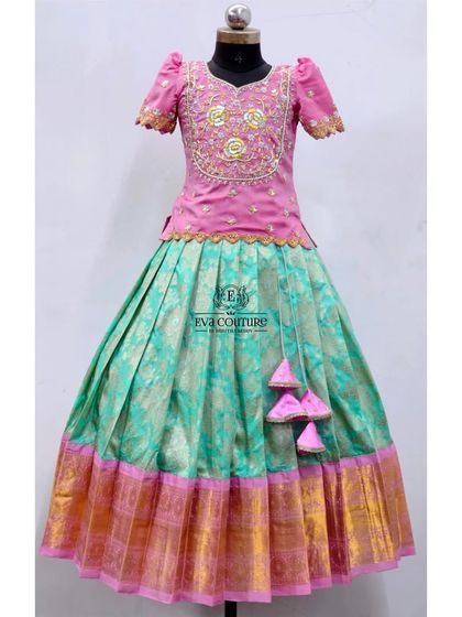A pastel combination of pink and seafoam green. This Banarasi lehenga has a beautifully embroidered blouse and a skirt with a wide gold border.
