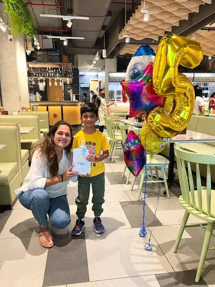 A proud birthday boy with his space-themed balloons and the art kit he gets to take home. It's a joy to be part of these special milestone celebrations.