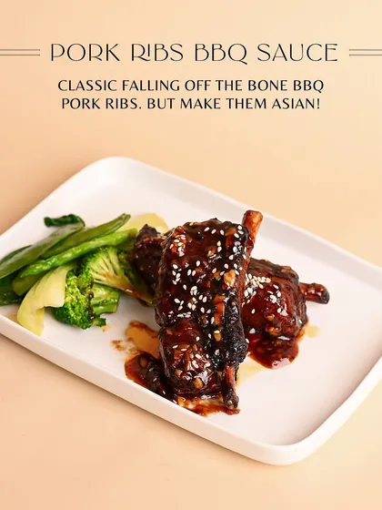 My take on a classic: fall-off-the-bone BBQ Pork Ribs with an Asian twist. They are glazed in a sticky, savory sauce, sprinkled with sesame seeds, and served with crisp steamed greens.