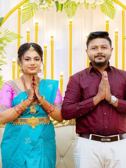 The couple greeting their guests. Sugirtha's makeup is flawless, and her bright blue and pink saree makes a beautiful statement.