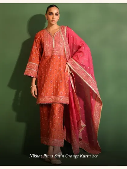 The Nikhat Pima Satin Orange Kurta Set is a bold and beautiful choice for the festive season.