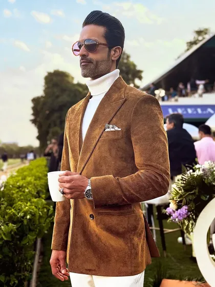 The rich texture of the brown corduroy blazer stands out in the sunlight, a perfect choice for outdoor events.