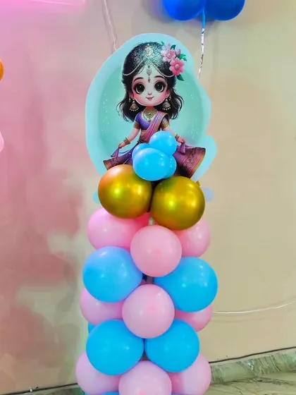 A detailed shot of a balloon pillar from the Kanha ji baby shower theme. The pillar is topped with a cute cutout of a goddess, adding a divine touch to the decor.