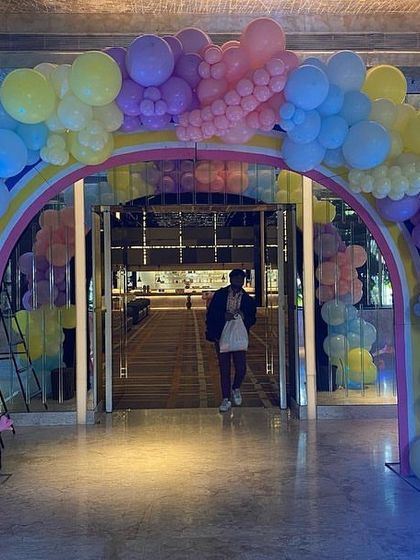 A magical rainbow balloon archway entrance for a Peppa Pig party, inviting guests into a world of fun and color.