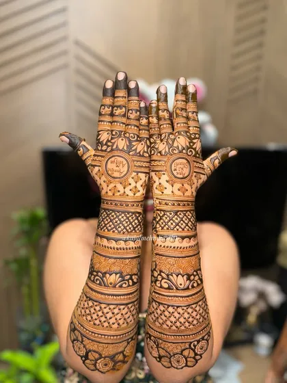 A classic Indian henna design with full coverage. This style features circular frames for initials, surrounded by bands of geometric and floral patterns.