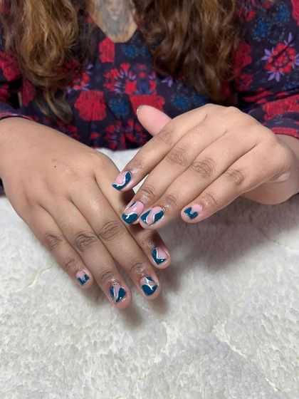 A geometric design with teal and pink on short nails. This shows that creative art can be done on any nail length.