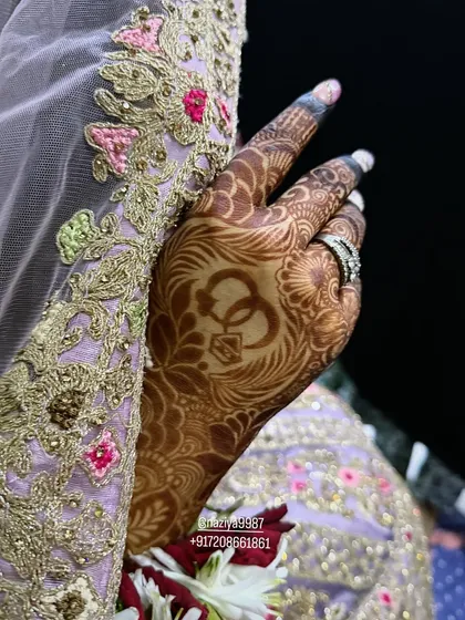 A symbol of union. This design features two interlocking rings, a popular and meaningful addition to any engagement or bridal mehendi.