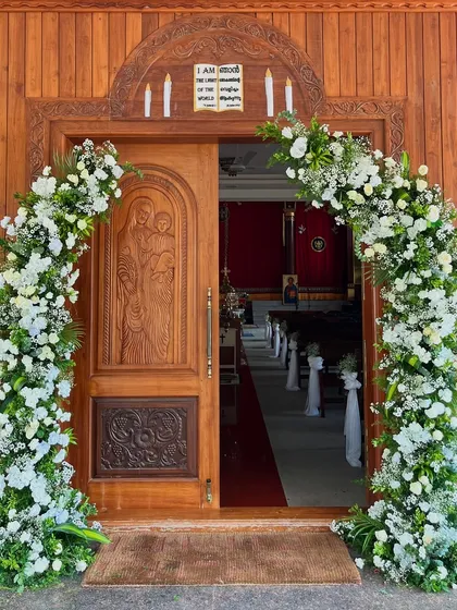 An entrance should always make a statement. For this church wedding, I designed a lush, full floral arch with white roses and fresh greenery to create a beautiful and welcoming entryway for the couple and their guests.
