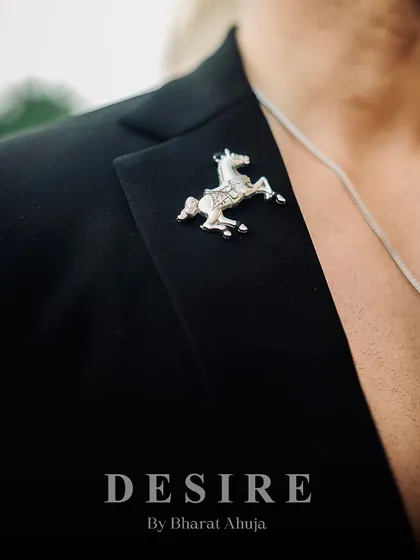 The signature horse brooch, a nod to classic western style, pinned on a modern denim-paneled blazer. It’s this fusion of old and new that defines my work.