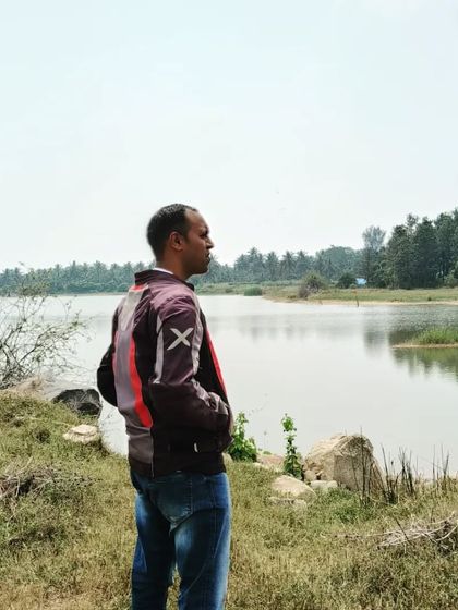 A rider takes a break to look out over the calm lake. Our trails offer these quiet moments to connect with nature in between the high-energy riding sections.