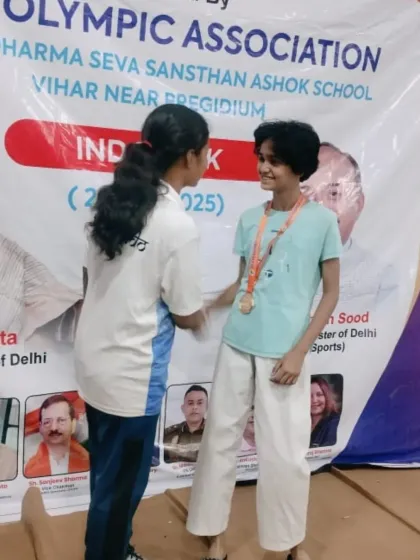 A moment of sportsmanship and celebration between teammates at the Delhi Olympic Games. Our academy is built on a foundation of mutual respect.