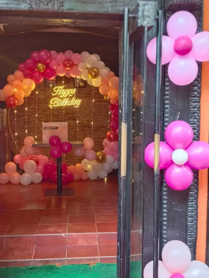 The entrance view of a party, giving a glimpse of the warm and inviting ring decoration inside, done in shades of pink, peach, and gold.