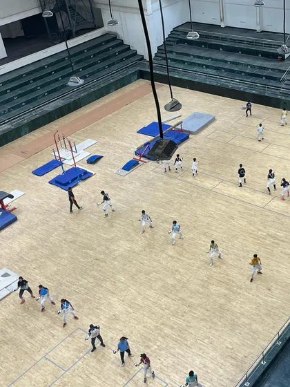 An overhead view of a collaborative training session with fencers from the Faridabad sports complex. We focused on footwork and agility drills in a large group setting.