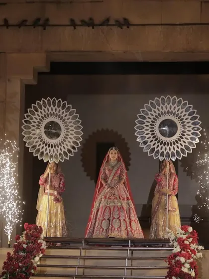 A queen's entrance. The bride stands poised for her royal walk, flanked by attendants and pyrotechnics, creating a moment of pure elegance and anticipation.