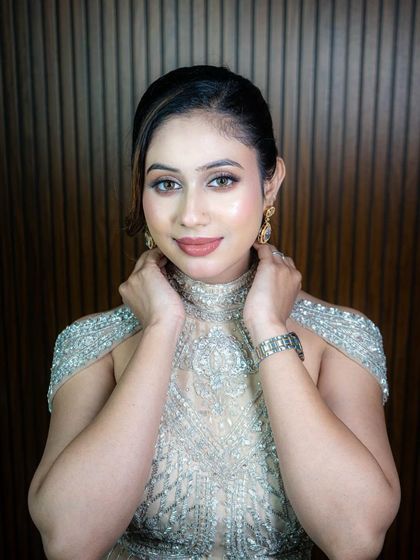A close-up of the stunning silver-beaded gown, showing the intricate work on the high-neck, cold-shoulder blouse.